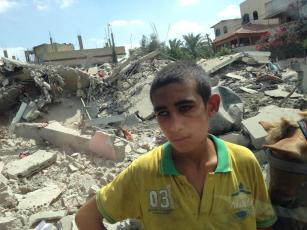Gaza - 26 July boy stands amid rubble in Beit Hanoun